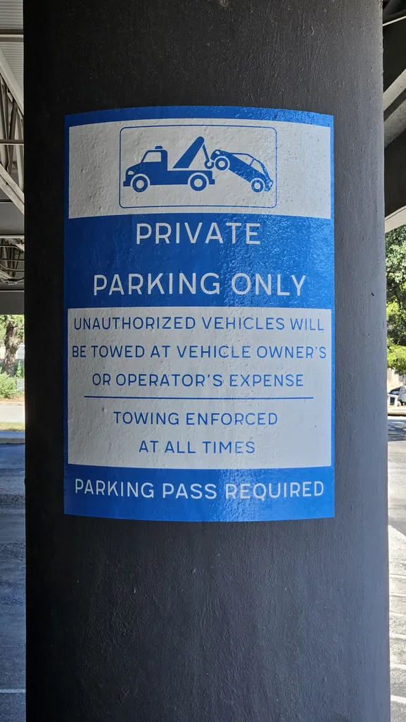 Private Parking Only sign: parking pass required and towing enforced at all times