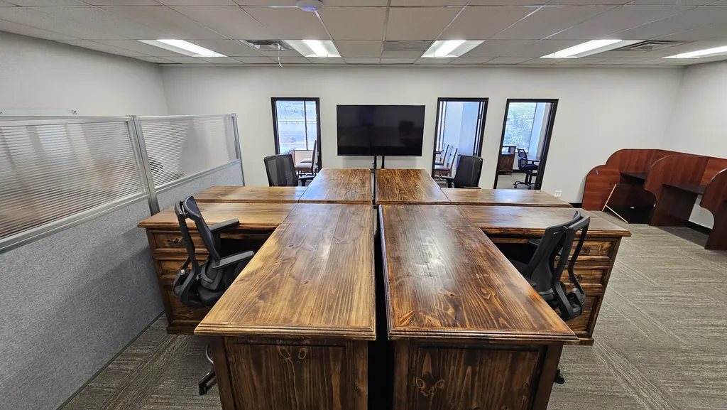 Executive desk pod with privacy panels in Suite 211, with the windowed private offices beyond