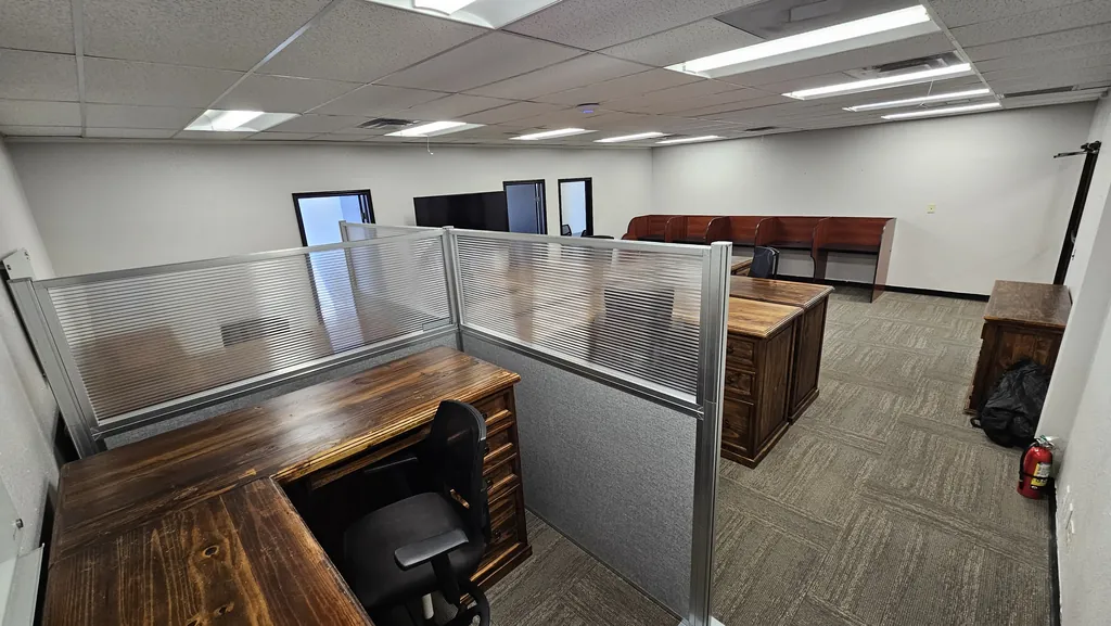 L-shaped wood workstation with frosted privacy dividers in Suite 211