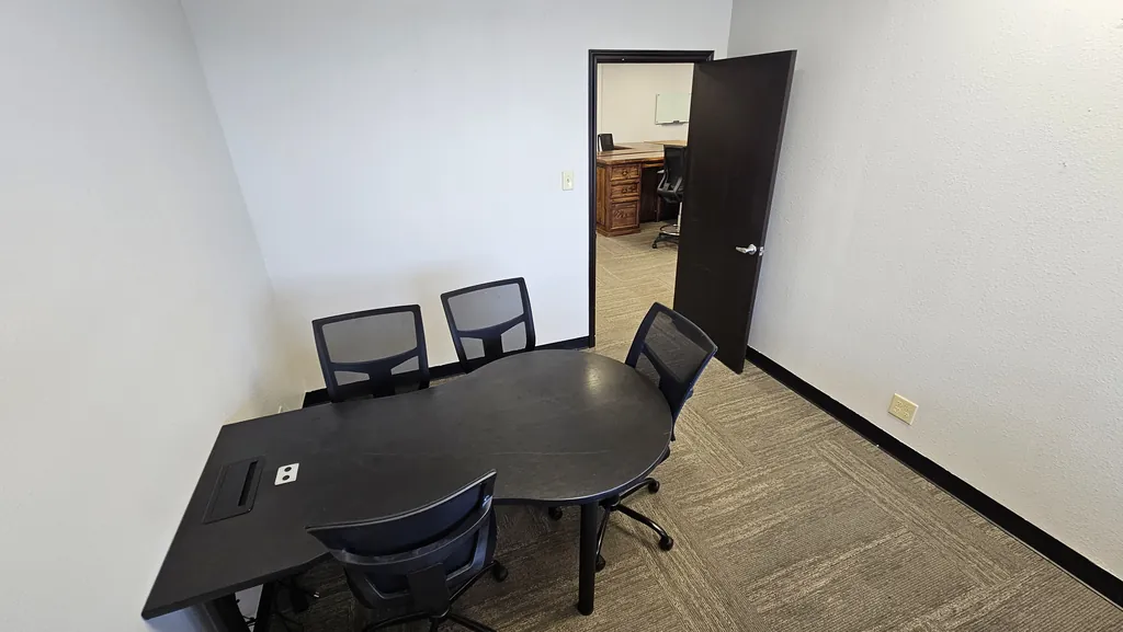 Meeting room table in Suite 211 with seating for four and a built-in power module