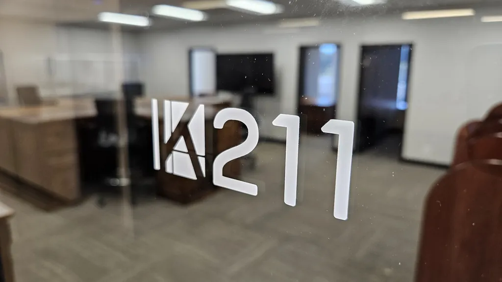 Room 211 suite number on the glass entry door at Kinected Coworking in San Antonio