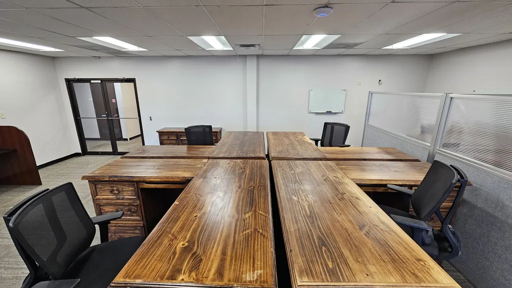 Wood desk pod and task chairs in Suite 211, looking toward the suite entrance doors