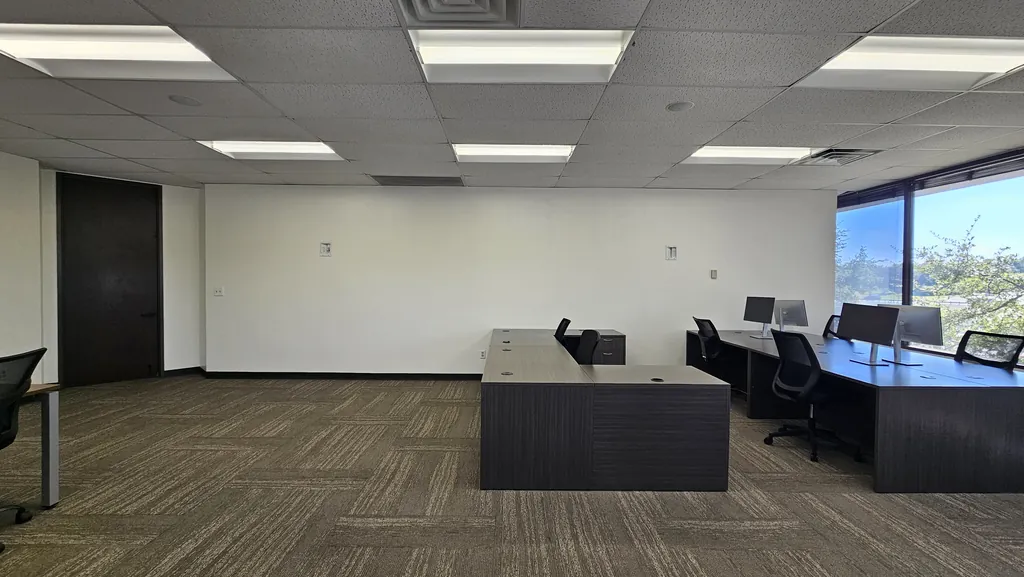 Executive desks and monitor workstations in Room 221 next to the corner windows