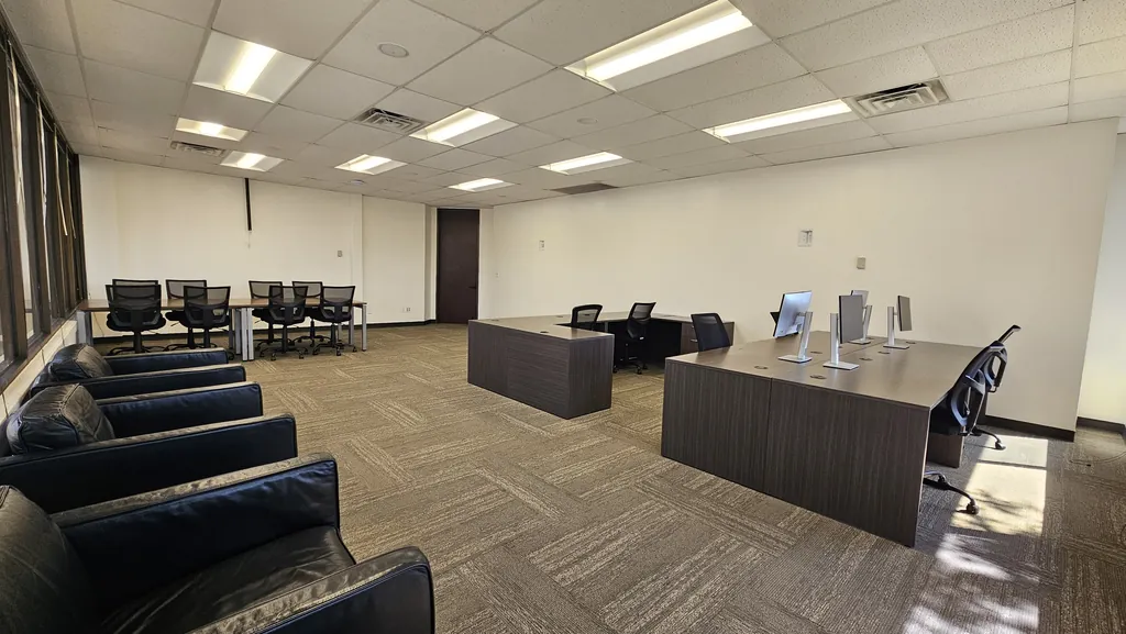 Leather lounge chairs, desks, and a row of workstations in Room 221