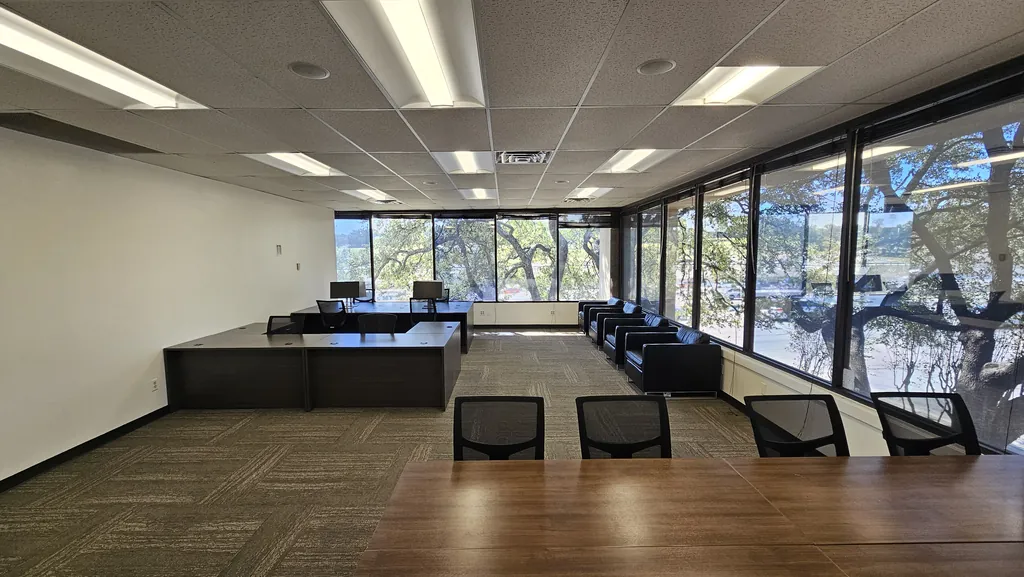 Conference table and long window wall with treetop views in Room 221