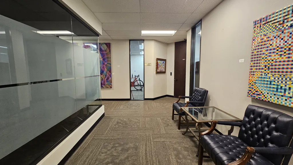 Second-floor hallway with artwork and lounge seating near Suite 221